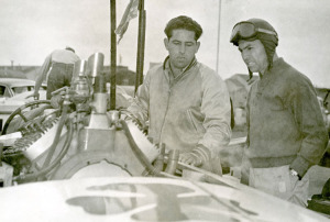 Joe and younger brother Manuel in front of a racing boat at the Oakland Estuary