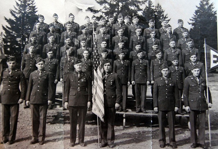 Ed Soares (holding American flag) with platoon, Mt. Rainier Ordnance Base, 1943